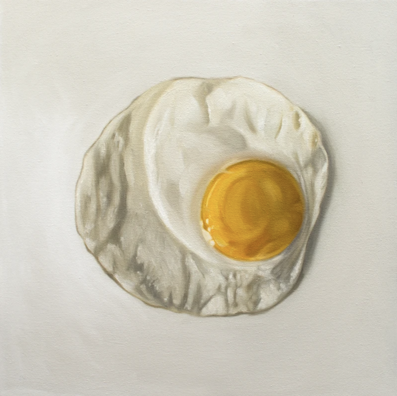 A simple fried egg resting on a light surface, viewed from above.