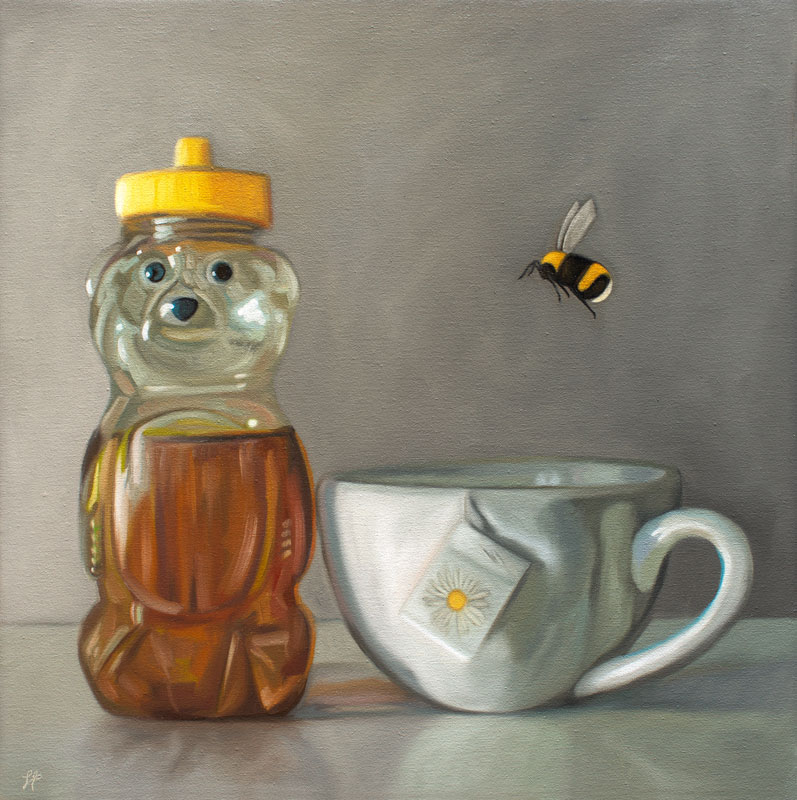 A bumble bee hovers over a cup of tea resting adjacent to a honey bear bottle.